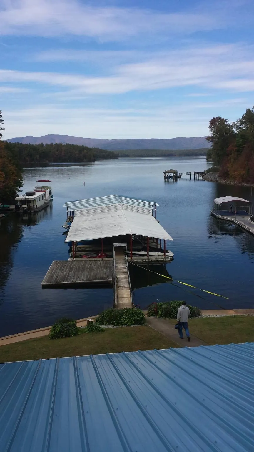 View across a lake from a newly installed blue metal roof in Henderson